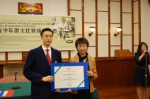 Mrs Lau Lee Mei Wah presents a certificate to the First Prize winner in the Junior Category – Mr Lam Tat Chung from King’s College. 