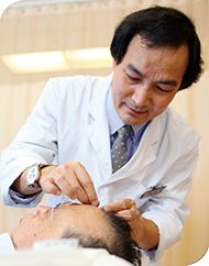 Professor Zhang performs acupuncture treatment on a patient
